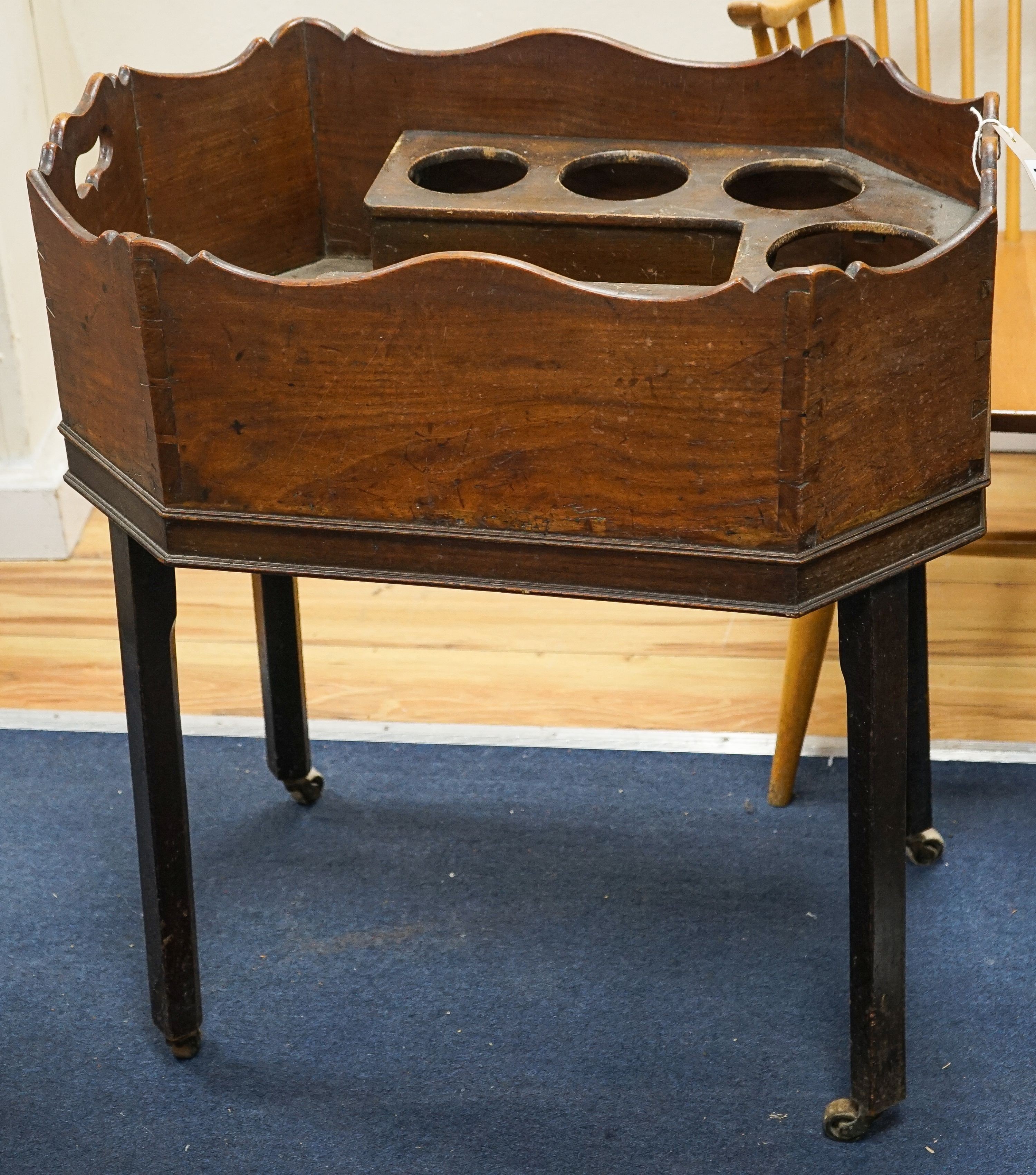 A Georgian cellarette or wine cooler of octagonal form, fitted for seven bottles, on four square legs with castors, width 66cm, depth 45cm, height 75cm